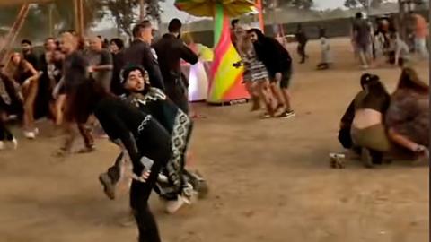 People huddled together under brightly coloured festival decorations