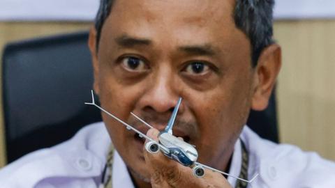 Air safety investigator Nurcahyo Utomo holds a Boeing 737 model as he speaks during a press conference on the final report of the Sriwijaya Air flight SJ-182 crash investigation in Jakarta, Indonesia