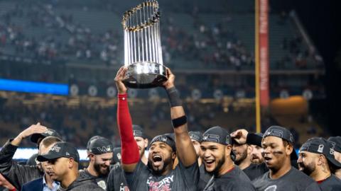 Boston Red Sox players celebrating with the World Series trophy