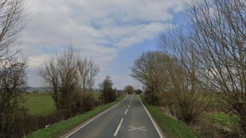 Google maps view of the A361 near Greylake in Somerset. Trees and fields can be seen either side of the road.