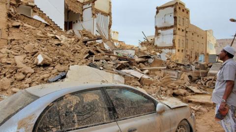 A man looks at a collapsed building in Tarim, Yemen, following flooding (3 May 2021)