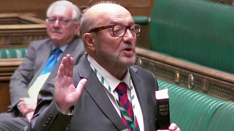 George Galloway raising his hand as he's sworn in to the House of Commons