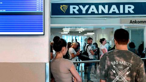 Cancelled Ryanair flights are seen on the announcement board as Ryanair passengers line up at the ticket counter at the terminal of the Skavsta Airport in Nykoeping, Sweden