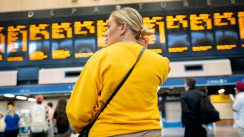 Woman looks at rail timetable