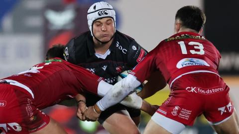 Henco van Wyk of Lions takes on Eddie James of Scarlets and Joe Roberts of Scarlets