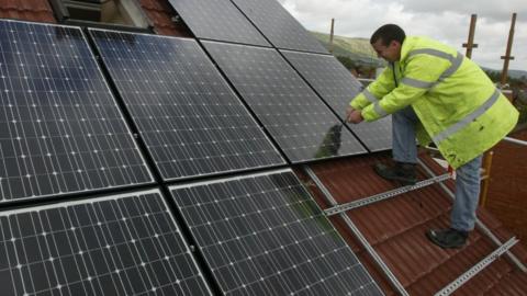 Builder installs solar panels on a roof