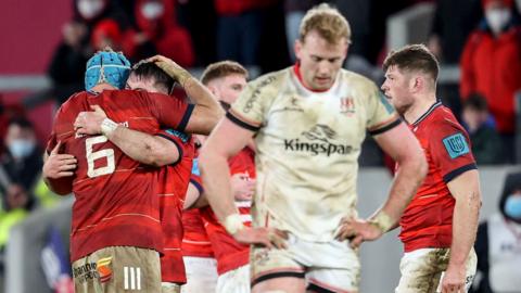 Ulster's Kieran Treadwell looks dejected as Munster players celebrate their win