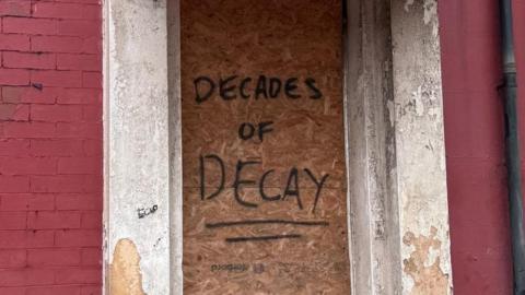Graffti reading "Decades of decay" on a building near Central Pier in Blackpool