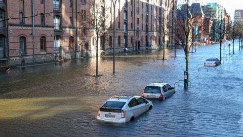 Flood waters surround cars parked at Hamburg"s Fish Market district