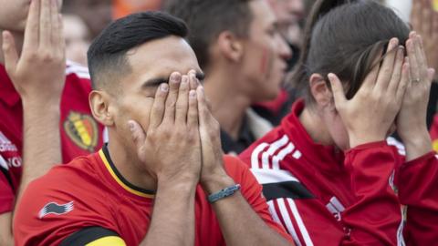 Belgian football fans react as they watch the World Cup semi-final match against France, 10 July 2018