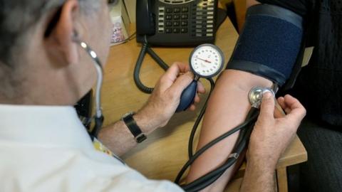 GP checking a patient's blood pressure