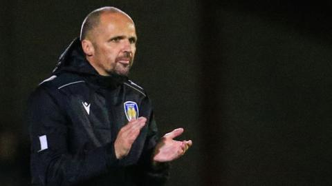 Colchester United interim head coach Matthew Etherington encourages his players during a match