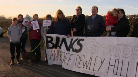 Protesters with banners at the Dewley Hill site