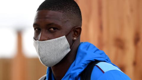 West Indies captain Jason Holder wears a face mask as he arrives at Manchester Airport for his side's Test tour of England