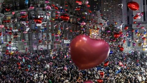 Revelers release balloons to celebrate the New Year on pedestrian street Jianghan Road on December 31, 2022 in Wuhan, China. (