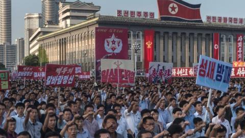 People wave banners and shout slogans as they attend a rally in support of North Korea's stance against the US, on Kim Il-Sung square in Pyongyang