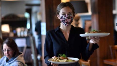 Waitress carries tray of food