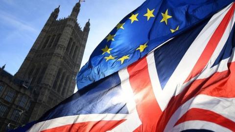 Union Jack and EU flags flying outside Parliament