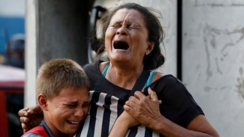 Relatives of inmates held at the General Command of the Carabobo Police react as they wait outside the prison where a fire occurred in the cells area, in Valencia, Venezuela March 28, 2018