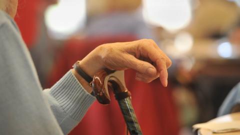 Elderly woman with walking stick