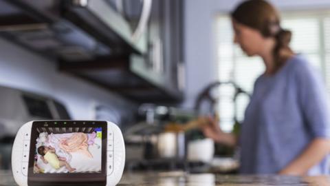 baby monitor screen with woman cooking in the background