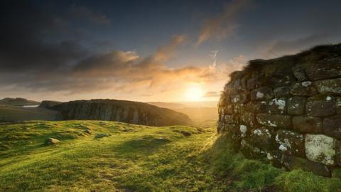 Sunrise at Steel Rigg in Northumberland. Hadrian's Wall is visible prominently in the foreground, as well as into the distance in the background