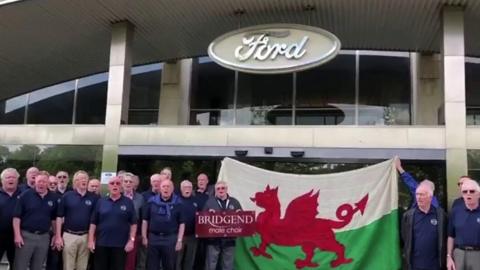 Bridgend Male Choir outside Ford headquarters in Essex