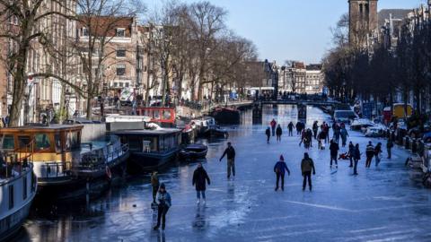 Skaters gather on ice on the canals in Prinsengracht, Amsterdam on February 13, 2021.