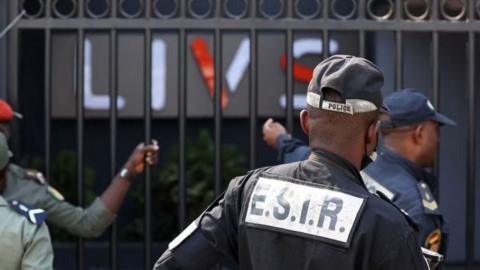 Policemen stand guard at the entrance of the Livs night-club where a deadly fire occurred in the Bastos district of Yaounde, on January 23, 202