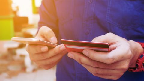 Generic image showing someone holding a bank card and a smartphone