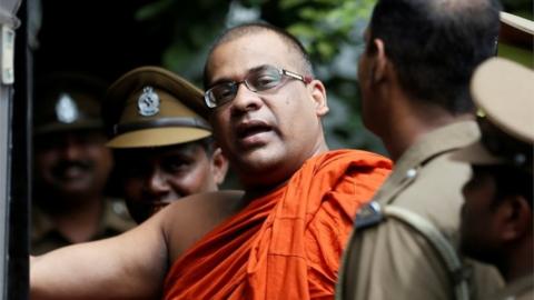 Sri Lankan BBS Secretary-General Galaboda Aththe Gnanasara Thero walks towards a prison bus while accompanied by prison officers after he was sentenced by a court for threatening Sandya Eknelygoda, wife of missing journalist Prageeth Eknaligoda, in Homagama, Sri Lanka June 14, 2018