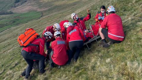 Mountain rescue team helping a paraglider