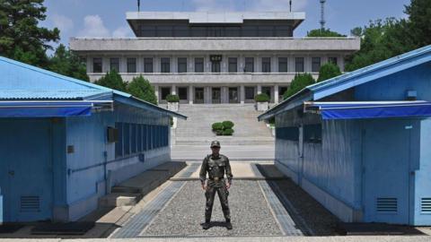 A South Korean soldier stands guard before the Military Demarcation Line (MDL) during a regular media tour at the border truce village of Panmunjom in the Demilitarised Zone