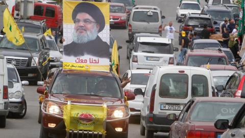 A man carries a picture of Hezbollah leader Hassan Nasrallah on election day in Bint Jbeil, in southern Lebanon, on 6 May 2018