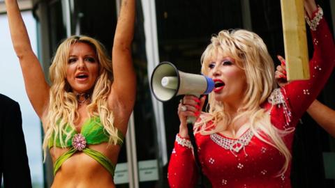Britney Spears and Dolly Parton tribute acts holding placards (out of view) outside the Meta office