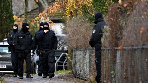 Police officers work during a raid in Berlin