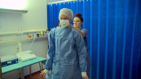 Medical staff put on their personal protective equipment.