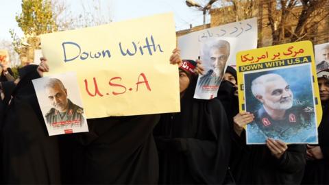 Iranian women hold up anti-US posters at a protest outside the British embassy in Tehran, Iran (12 January 2020)