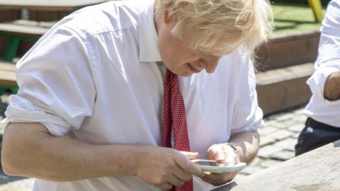 Boris Johnson using a mobile phone last year