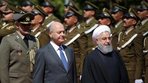 Iraqi President Barham Saleh (L) inspects troops with Iranian President Hassan Rouhani (L) in Baghdad (11 March 2019)