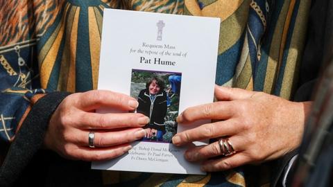 Woman holding Funeral booklet