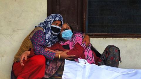 Women mourn the death of a family member in India