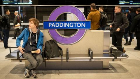 A man sits on the Elizabeth line platform a Paddington