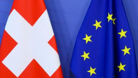 Switzerland"s national flag and the European Union flag are seen at the European Commission building in Brussels, Belgium April 23, 2021