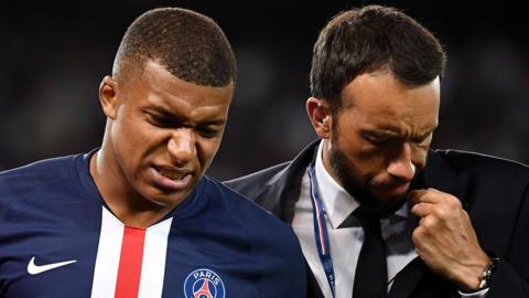 Kylian Mbappe is helped from the field after suffering an injury playing for Paris St-Germain