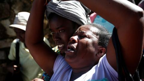 Women react after a fire destroyed part of an orphanage, in Port-au-Prince, Haiti, 14 February, 2020.