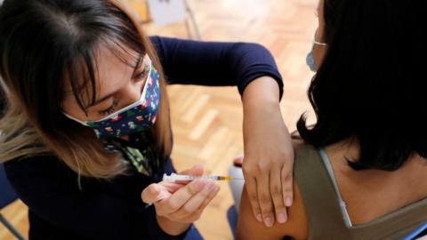 A woman receives a dose of a Covid vaccine at a vaccination centre in Santiago