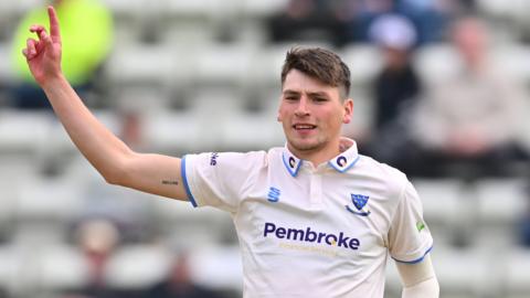 Sussex bowler Henry Crocombe celebrates taking a wicket