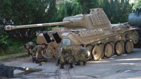 A World War Two Panther battle tank is made ready for transportation from a residential property in Heikendorf, Germany, 2 July 2015