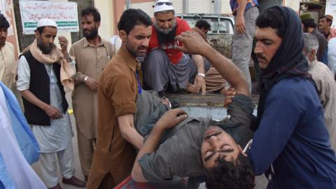 People carry a coal miner who was injured in a mine explosion to a hospital in Quetta, Pakistan, 5 May 2018.